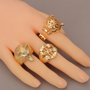 Macro view of gold-plated hip hop rings featuring wolf head, dollar sign and leopard designs