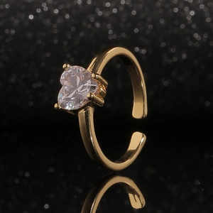Bague élégante plaqué or en forme de cœur avec zircone claire sur fond noir poli