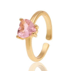 Détail d'une bague ajustable dorée ornée d'une pierre précieuse rose en forme de cœur poli