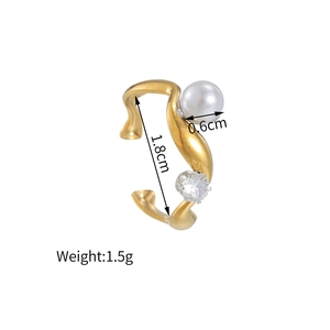 Détail de la bague d'oreille en or 18k avec perle blanche et pierre de zircone