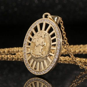 Detailed macro view of gold-plated Virgin Mary pendant with cubic zirconia inlay stones