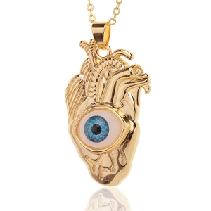 Detailed view of gold anatomical heart pendant with realistic blue evil eye inlay