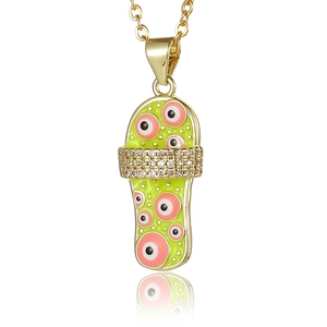 Macro-detail van gouden slippers-hanger met groen email en roze boze oog bedels
