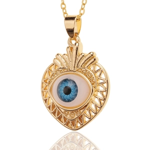 Detailed view of heart-shaped gold-plated Evil Eye pendant with ray patterns