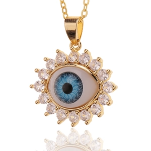 Macro shot of gold-plated evil eye pendant necklace with sparkling crystal inlay