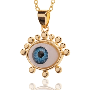 Detailed close-up of gold-plated evil eye pendant with blue iris and bead accents