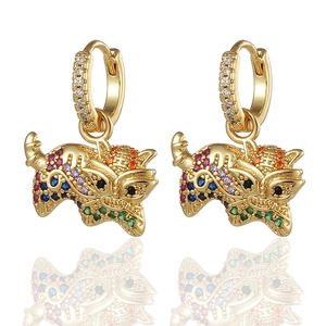Detalle macro de pendientes de león dorado de la suerte con circonitas de colores vivos