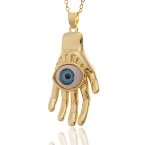 Golden Hamsa Hand pendant necklace with blue Evil Eye charm on white background
