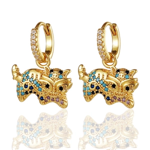 Detalle de pendientes de tigre dorados con circonitas de colores y pavé de piedras blancas