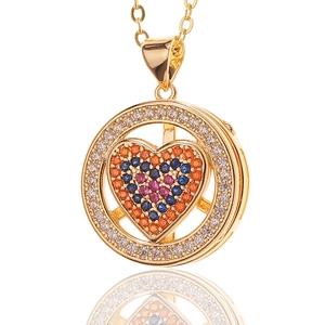 Detailopname van gouden hartketting met gekleurde zirkoon en roterende buitenste ring