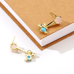 Gold plated cute mouse dangle earrings with pink and blue stones on notebook