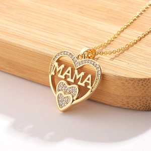Golden MAMA heart necklace with micro-pave crystals on elegant light wood background