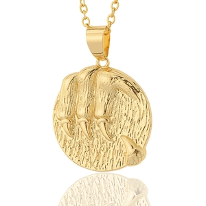 Macro view of 18K gold plated coin pendant featuring detailed embossed paw print