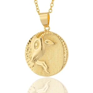 Macro detail of gold-plated 18K Capricorn zodiac coin pendant with embossed goat pattern