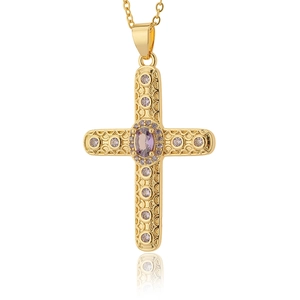 Dettaglio del ciondolo a croce in oro 18K con gemma ovale viola e motivi a rilievo fini