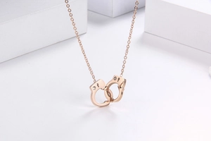 Macro detail of rose gold handcuff pendant necklace with sparkling crystal accents