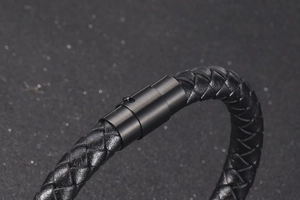 Close-up of black braided leather bracelet featuring a textured magnetic metal clasp