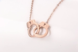 Detail of rose gold handcuff pendant necklace with polished finish on O-chain