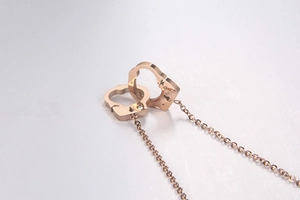 Detailed close-up of rose gold interlocking handcuffs necklace with a small diamond accent