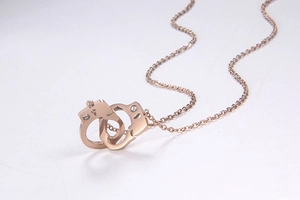 Detailed view of rose gold handcuff pendant necklace with sparkling crystal accents