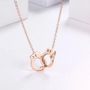 Minimalist rose gold titanium handcuff necklace with sparkling stones on white background