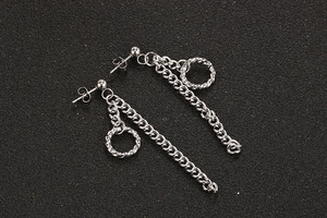 Detailopname van punk kettingoorbellen van titaniumstaal met ringen op zwarte achtergrond