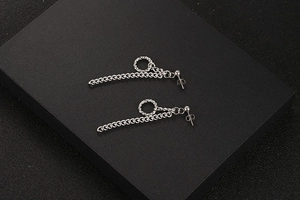 Detail van zilveren titanium stalen kettingoorbellen met getextureerde ringen en sluiting