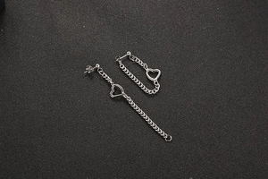 Vue détaillée des boucles d'oreilles cœur en acier titane avec chaînes pendantes