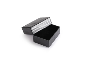 Macro view of textured black jewelry gift box with silver diamond pattern inner lid