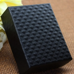 Elegant black jewelry gift box with textured diamond pattern finish on brown burlap