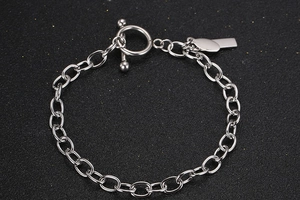 Nahaufnahme eines Titanstahl-Kettenarmbandes mit OT-Verschluss und Metallanhänger