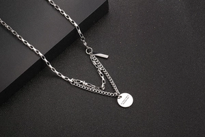 Close-up of double-layer stainless steel necklace with engraved quote round pendant