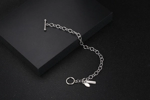 Minimalistisches Titanstahl-Armband mit OT-Verschluss und Metallanhängern auf Schwarz