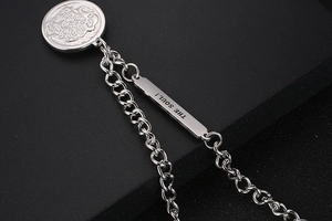 Macro view of silver OT buckle chain necklace with circular pendant and THE SOUL engraving