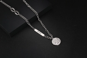 Detailed shot of steel chain necklace featuring 'THE SOUL!' bar and retro coin pendant