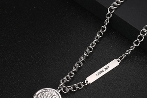 Macro detail of OT buckle necklace with THE SOUL engraved tag and coin pendant