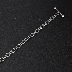 Minimalistisches Edelstahl-Kettenarmband mit klassischem OT-Knebelverschluss auf dunklem Grund