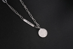 Macro detail of silver OT buckle necklace with soul pendant and round medallion charm