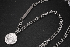 Macro view of silver round coin pendant with soul engraved plaque on link chain