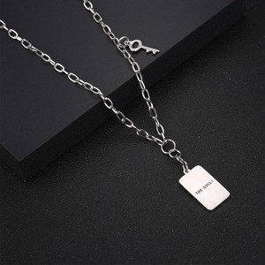 Collar minimalista plateado con llave y placa rectangular grabada con THE SOUL!