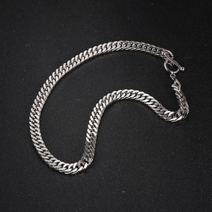 Bracciale a catena groumette d'argento con chiusura a barra OT su sfondo scuro testurizzato