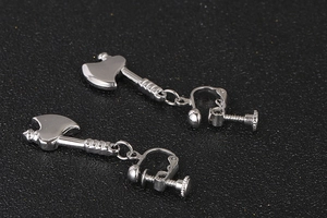 Detailed macro view of creative polished stainless steel axe shaped clip-on earrings