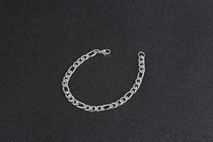 Detail of silver Figaro chain bracelet showing classic link pattern and lobster clasp closure