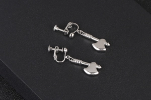 Macro shot of silver axe shaped earrings with spiral clip-on fasteners on black background