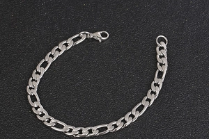 Detailed close-up of Figaro style silver stainless steel chain link with lobster clasp