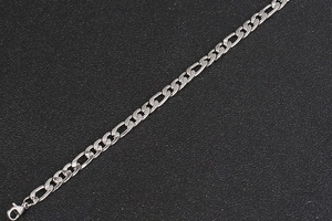 Macro shot of silver Figaro style steel chain link texture with lobster claw clasp