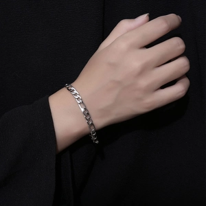 Sleek Figaro chain bracelet in silver titanium steel worn on wrist with black background