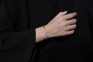 Dettaglio di un bracciale a catena con maglie rettangolari argentate sul polso