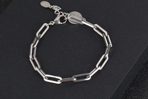 Dettaglio di un bracciale a catena a graffetta in acciaio argento con chiusura a moschettone