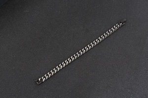 Détail macro de la gourmette en acier inoxydable gris foncé mat avec fermoir robuste